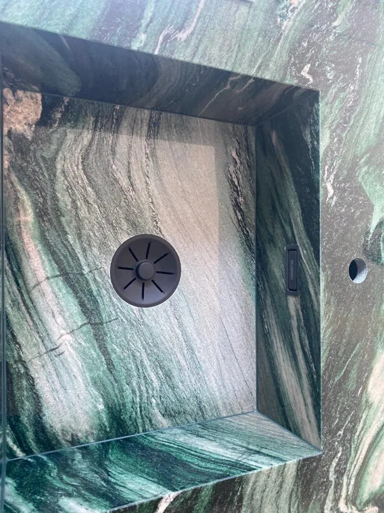 Detail: Ablaufventil in einer grünen Natursteinplatte